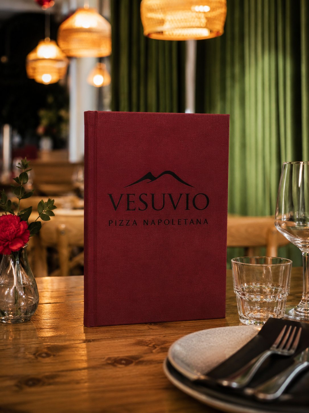 Bordo rdeč meni Vesuvio Pizza Napoletana na leseni mizi v italijanski restavraciji z zelenimi žametnimi zavesami.